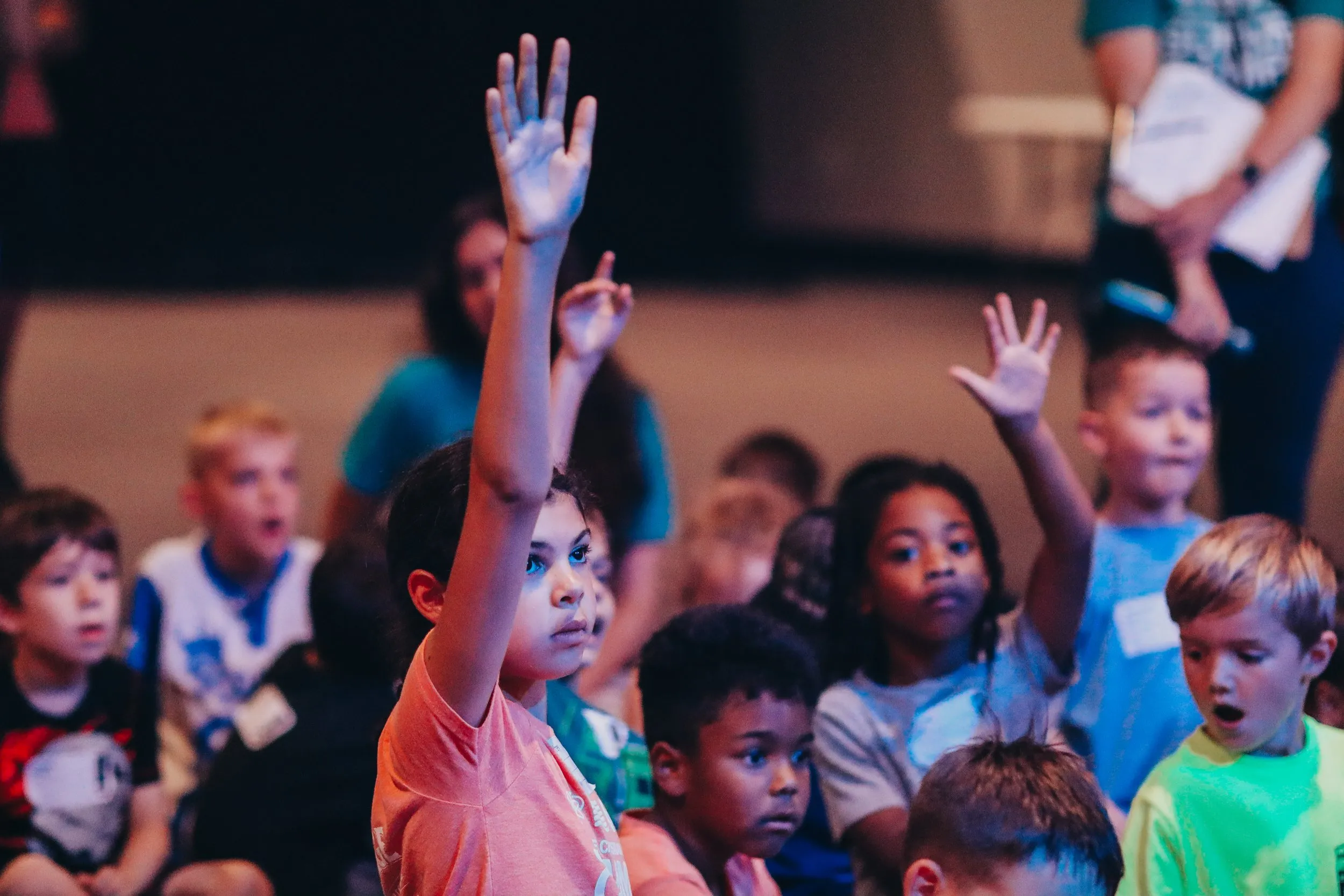 Vintage Christian Academy students raise their hands together at a school assembly